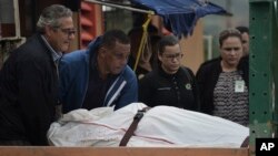 Trabajadores de la morgue en Puerto Rico retiran el cuerpo de un hombre muerto de un disparo, encontrado en San Juan. Enero 11, 2018. 