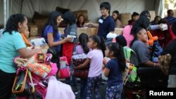 FILE - People receive free blankets as Thanksgiving meals are served in the Skid Row district of Los Angeles, California, Nov. 23, 2016. 