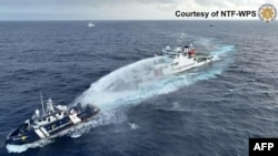 A China Coast Guard ship (R) deploying water cannon at the Phillipine Bureau of Fisheries and Aquatic Resources vessel BRP Datu Pagbuaya (L) near Scarborough Shoal in disputed waters of the South China Sea, Dec. 4, 2024. (National Task Force for the West Philippine Sea/Handout)