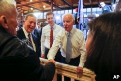 FILE - Conor Lamb, left center, the Democratic candidate for the March 13 special election in Pennsylvania's 18th Congress and former Vice President Joe Biden, center, work a crowd of supporters during a rally at the Carpenter's Training Center in Collier