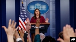 អ្នក​សារព័ត៌មាន​លើក​ដៃ​ដើម្បី​សួរ​សំណយរ​ទៅ​អ្នកស្រី Sarah Huckabee Sanders ក្នុង​សន្និសីទ​កាសែត​ប្រចាំ​ថ្ងៃ​ នៅ​សេតវិមាន កាលពី​ថ្ងៃទី១០ ខែមេសា ឆ្នាំ២០១៨។