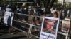 A poster featuring army chief Senior General Min Aung Hlaing is displayed on a barricade as protesters take part in a demonstration against the military coup in front of the Central Bank of Myanmar in Yangon, Feb. 11, 2021.