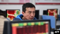 中国安徽省阜阳市的一名投资者正在查看显示股市走势。（2024年1月17日）