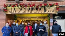 Voluntarios y observadores internacionales frente al restaurante La Cachapera Bcn, uno de los puntos de asistencia técnica durante la jornada de votación de la consulta popular en Barcelona, España, el 12 de diciembre de 2020. [Foto VOA/Júlia Riera]..