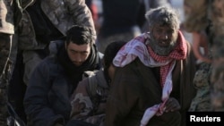 Para pria yang ditahan oleh Pasukan Demokratik Suriah setelah keluar dari kantong ISIS terakhir dekat Desa Baghouz, Provinsi Deir Al Zor, Suriah, 1 Maret 2019. (Foto: Reuters) 