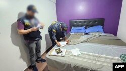 Imagen publicada por la Policía Federal Argentina el 3 de enero de 2024, que muestra a agentes de policía registrando una habitación durante el operativo que "neutralizó posible célula terrorista".