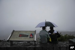 A couple sits on the edge of the Jaggar Museum's overlook to view Kilauea's summit crater in Volcanoes National Park, Hawaii, May 10, 2018.