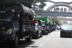 Policemen sit inside trucks parked on a road in the downtown area of Yangon, Myanmar Monday, Feb. 1, 2021.