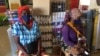 Duas mulheres deslocas esperam pelos seus produtos dentro de uma loja contratada pelo PMA para fornecer produtos aos que fogem da violência armada no norte de Cabo Delgado. Moçambique
