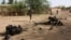 (Photo d’archives) Des soldats nigériens marchent près des débris après une attaque-suicide à l'intérieur d'une caserne militaire, à Agadez, dans le nord du Niger, le jeudi 23 mai 2013.
