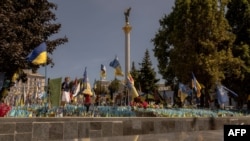 Жінка відвідує місце вшанування пам'яті загиблих українських та іноземних бійців під час Дня Незалежності України на Майдані Незалежності в Києві, 24 серпня 2024 року. (Фото Романа ПІЛІПЕЯ / AFP)