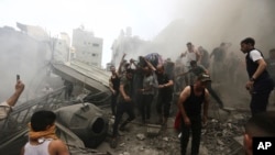 Sejumlah warga Palestina tampak mengevakuasi jenazah dari reruntuhan bangunan setelah serangan udara Israel menyerang kamp pengungsi Jebaliya, Jalur Gaza, pada 9 Oktober 2023. (Foto: AP/Ramez Mahmoud)