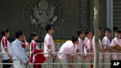In this May 2012 file photo, Chinese students wait outside the U.S. Embassy for their visa application interviews in Beijing, China. The Open Doors report says the number of international students in the U.S. has increased from 764,000 in 2011 to more than 1 million in 2020.