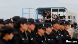 中国警察在柬埔寨金边国际机场向中国境内押送被引渡的电信诈骗案嫌疑人。（2016年6月24日）