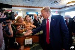 Mantan Presiden AS Donald Trump menyapa para pendukungnya saat mengunjungi restoran "Versailles" di kota Miami, Florida Selasa, 13 Juni 2023.