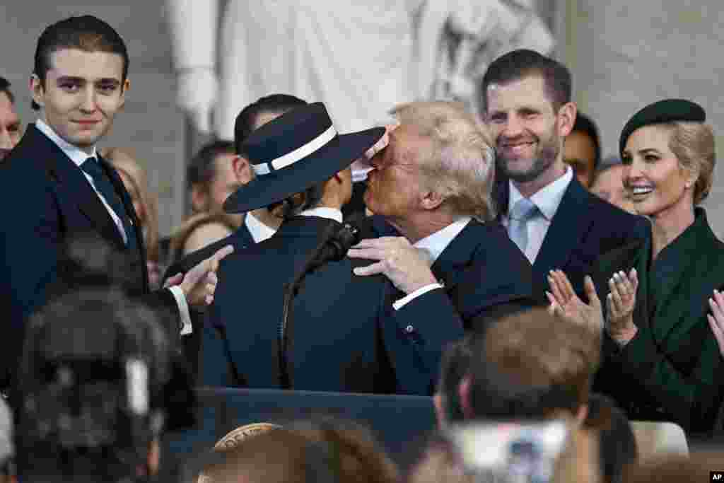 President Donald Trump, center right, reaches to kiss his wife Melania Trump as his children watch during the 60th Presidential Inauguration in the Rotunda of the U.S. Capitol in Washington, Jan. 20, 2025.
