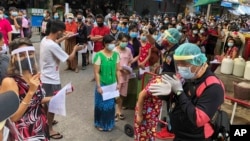 រូបឯកសារ៖ មនុស្សជាច្រើនដែលភាគច្រើនជាពលករចំណាកស្រុកឈរតម្រង់ជួរដើម្បីធ្វើតេស្តរកជំងឺកូវីដ១៩ នៅខេត្ត Samut Sakhon ប្រទេសថៃ កាលពីថ្ងៃទី២០ ខែធ្នូ ឆ្នាំ២០២០។