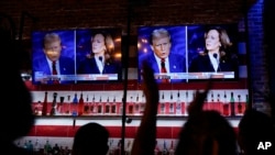 FILE - Viewers cheer as they watch a debate between Democratic presidential nominee Vice President Kamala Harris and Republican presidential nominee former President Donald Trump at the Angry Elephant Bar and Grill, in San Antonio, Sept. 10, 2024.