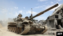 A picture taken April 8, 2018, shows Syrian army soldiers advancing in an area on the eastern outskirts of Douma, as they continue their fierce offensive to retake the last opposition holdout in Eastern Ghouta.