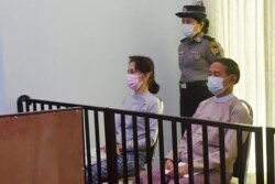 This handout photo taken on May 24, 2021 and released by Myanmar's Ministry of Information on May 26 shows detained civilian leader Aung San Suu Kyi (L) and detained president Win Myint (R) during their first court appearance in Naypyidaw, since the milit