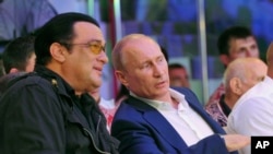 In this photo taken on Saturday, Aug. 11, 2012, Russian President Vladimir Putin and U.S. actor Steven Seagal watch the first Russian national championship of mixed martial arts in the Black Sea resort of Sochi, southern Russia.