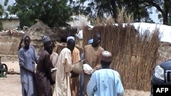 Men carry a victim after an attack by Boko Haram militants on a funeral in Budu, near Maiduguri, northeast Nigeria, July 28, 2019.