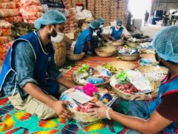 Members of Bidyanondo Foundation pack packages for distribution to COVID-19 patients in Dhaka, Bangladesh, June 6, 2020.