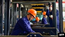 中國山東省青州市一家工廠的工人正在生產挖土機駕駛室。 (2024年10月31日)