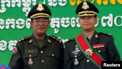 រូបឯកសារ៖ លោក​នាយករដ្ឋមន្ត្រី ហ៊ុន សែន (ឆ្វេង) ថតរូប​ជាមួយ​នឹង​កូន​ប្រុស​ច្បង​របស់​លោក​ គឺ​លោក ហ៊ុន ម៉ាណែត​ នៅ​ជាយ​រាជធានី​ភ្នំពេញ ថ្ងៃទី១៣ ខែតុលា ឆ្នាំ២០០៩។ (REUTERS/Chor Sokunthea/File Photo)