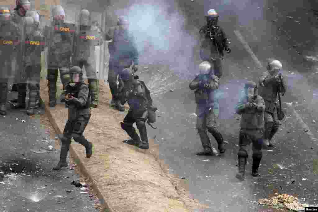 National Guard troops fire against demonstrators during a protest against Venezuelan President Nicolas Maduro's government in San Cristobal, Feb. 27, 2014. 