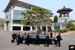 North Korean security persons run by a car carrying North Korean leader Kim Jong Un returning to the North side for a lunch break after a morning session of a summit meeting with South Korean President Moon Jae-in at the border village of Panmunjom in Demilitarized Zone, April 27, 2018.
