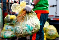 Seorang pekerja membawa kantong sampah medis di Jakarta. (Foto: REUTERS/Ajeng Dinar Ulfiana)