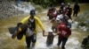 Un grupo de migrantes de Venezuela, Ecuador y Haití cruzan el río Muerto en el Tapón de Darién, mientras continúan su viaje hacia la frontera de EEUU, en Acandi, Colombia, el 9 de julio de 2023.