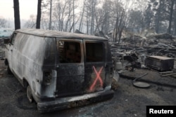Una furgoneta marcada por equipos de rescate en medio de restos calcinados de viviendas en Paradise, California, luego del incendio Camp. Noviembre 17 de 2018.