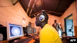 FILE - Young men surf the internet at a cyber cafe on June 20, 2012 in Kibera slum in Nairobi.