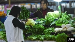 This photo taken on November 1, 2021 shows a resident buying vegetables at a market in Nanning, in China's southern Guangxi region. (Photo by AFP)