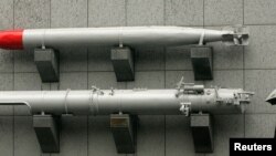 ARHIVA - Čovek sa kišobranom prolazi pored torpeda, koji je izložen ispred Muzeja oružanih snaga Tajvana u Tajpeju, 7. januara 2010. (Foto: Reuters)