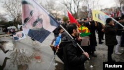 FILE - Demonstrators wave flags with the image of imprisoned Kurdish rebel leader Abdullah Ocalan during a rally in Istanbul, Feb. 15, 2015. Ocalan called on followers to agree to lay down their arms.