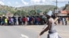 Um veículo blindado militar bloqueia a estrada enquanto os manifestantes tentam chegar ao posto fronteiriço de Ressano Garcia, entre Moçambique e a África do Sul, em 13 de novembro.