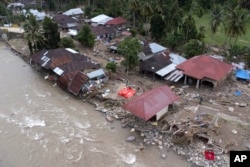 Homes damaged by a flash flood sit in Pesisir Selatan, West Sumatra, Indonesia, Wednesday, March 13, 2024. (AP Photo/Sutan Malik Kayo)