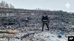 Співробітник Слідчого комітету Росії біля уламків Іл-76 у Бєлгородській області Росії. Фото оприлюднине Слідчим комітетом Росії 25 січня 2024 року,