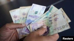 Un empleado cuenta pesos colombianos en una tienda en Bogotá, Colombia, el 28 de diciembre de 2018.