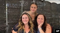 Traci Cangiano, seated right, with her daughters Daniella, left, and Kristina organized a Facebook group that traded homemade recipes during the pandemic. (Vinny Cangiano via AP)