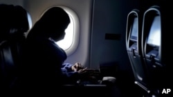 ARHIVA - Putnica nosi masku na letu iz Atlante (Foto: AP/Charlie Riedel)