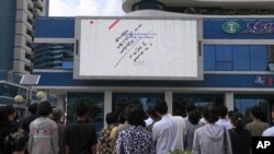 지난 2017년 평양 시민들이 전광판에서 나오는 6차 핵실험 시행 관련 소식을 지켜보고 있다. (자료사진)