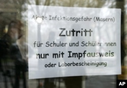 FILE - A sign at the entrance of a school in Freiburg, southern Germany, April 11, 2008, advises that only vaccinated children are allowed to enter.