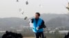 Park Sang-hak, pengungsi Korea Utara, yang menerbangkan balon-balon yang membawa pamflet propaganda anti-Korea Utara, sedang menyebarkan pamflet di sebuah jalan di Paju, dekat zona demiliterisasi, Korea Selatan, 22 Oktober 2012. (Foto: Ahn Young-joon/AP Photo)