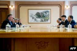 FILE - U.S. Secretary of State Mike Pompeo, left, speaks during a meeting with North Korea's director of the United Front Department, Kim Yong Chol, right, at the Park Hwa Guest House in Pyongyang, July 6, 2018.