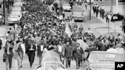 FILE - In this March 17, 1965, file photo, demonstrators walk to the courthouse behind the Rev. Martin Luther King Jr. in Montgomery, Alabama. (AP Photo/File)