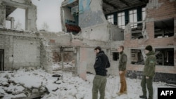 Des soldats ukrainiens visitent le site des bombardements russes où leurs camarades sont morts, lors d'un événement dédié à la mémoire des soldats ukrainiens tombés, à Kharkiv le 2 mars 2025.